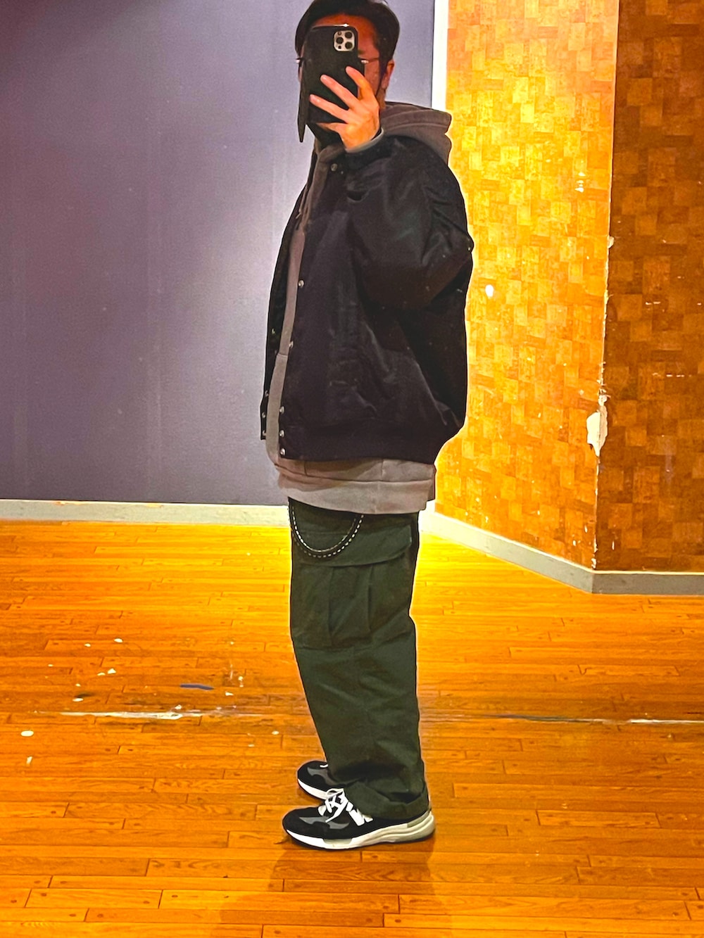 ブラック系のジャケット/アウター、グレー系のパーカー、グリーン系のカーゴパンツを着用したメンズの春コーディネートの2枚目の写真