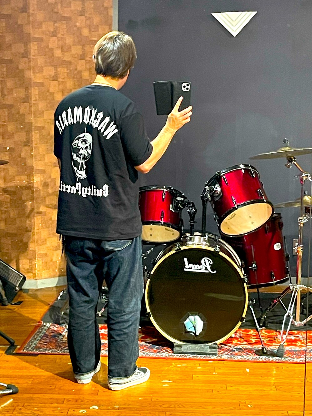 ブラック系のTシャツ/カットソー、ブルー系のデニムパンツ、ブラック系のスニーカーを着用したメンズの秋コーディネートの3枚目の写真