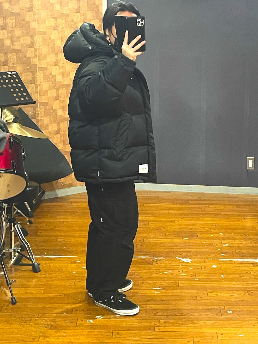 ブラック系のダウンジャケット/コート、ブラック系のパーカー、ブラック系のカーゴパンツを着用したメンズの冬コーディネートの2枚目の写真