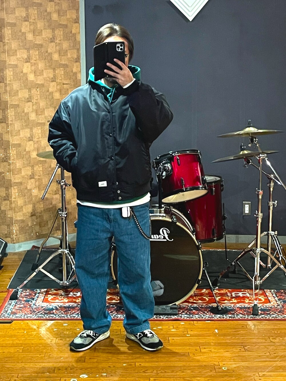 ブラック系のジャケット/アウター、ブルー系のデニムパンツ、ブルー系のスニーカーを着用したメンズの秋コーディネートの5枚目の写真