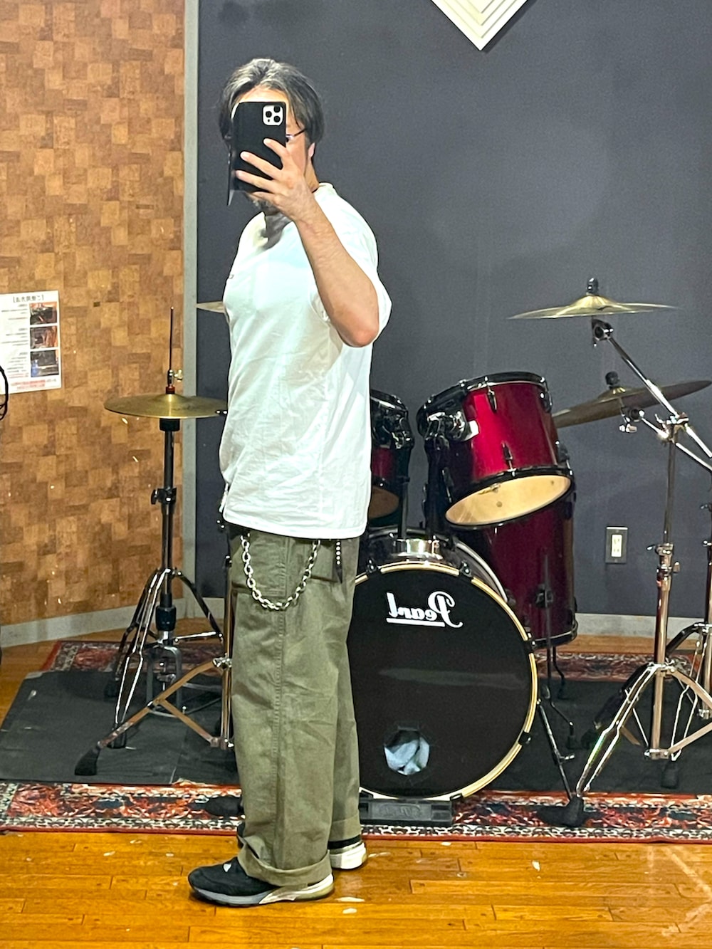 ホワイト系のTシャツ/カットソー、グリーン系のパンツ、ブラック系のスニーカーを着用したメンズの秋コーディネートの2枚目の写真