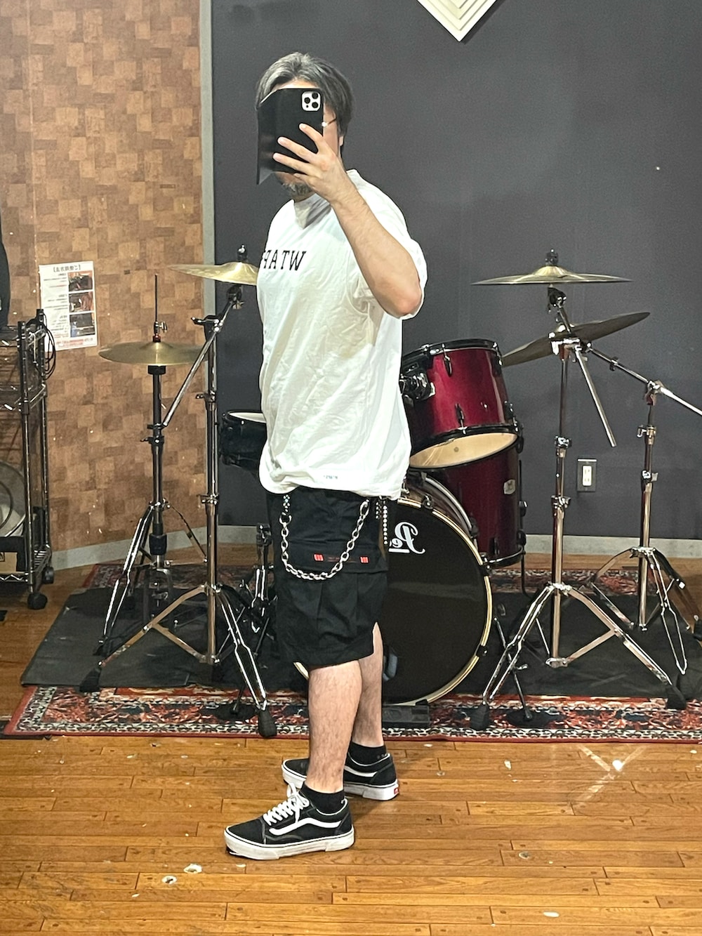ホワイト系のTシャツ/カットソー、ブラック系のカーゴパンツ、ブラック系のスニーカーを着用したメンズの秋コーディネートの3枚目の写真