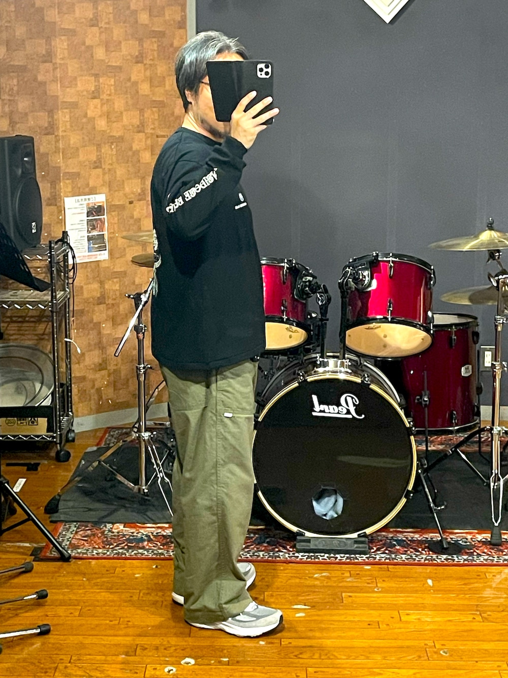 ブラック系のTシャツ/カットソー、グリーン系のパンツ、グレー系のスニーカーを着用したメンズの秋コーディネートの3枚目の写真