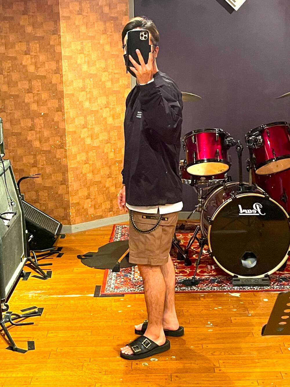 ブラック系のトップス、ベージュ系のカーゴパンツ、ブラック系のサンダルを着用したメンズの夏コーディネートの3枚目の写真