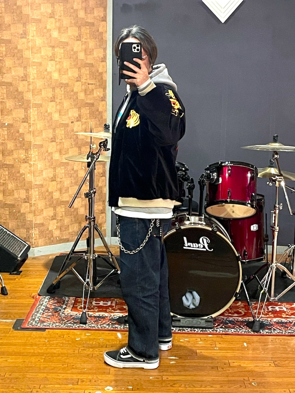 ブラック系のスカジャン、グレー系のパーカー、ブルー系のデニムパンツを着用したメンズの冬コーディネートの2枚目の写真