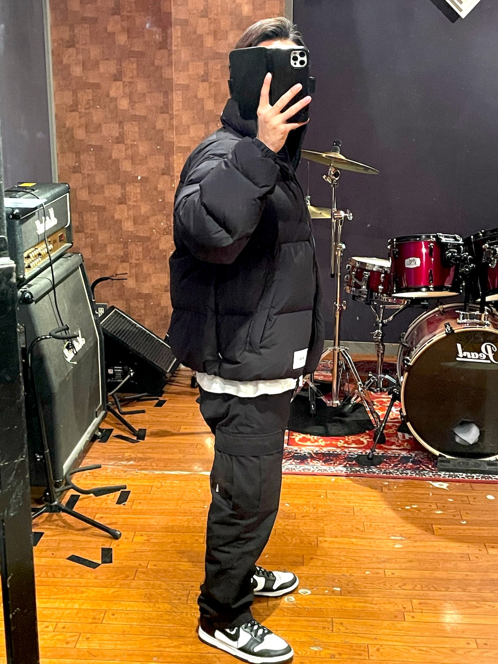 ブラック系のダウンジャケット/コート、ホワイト系のTシャツ/カットソー、ブラック系のカーゴパンツを着用したメンズの冬コーディネートの2枚目の写真