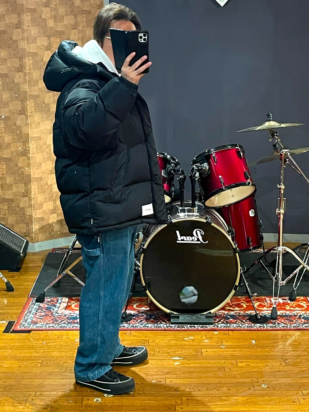 ブラック系のダウンジャケット/コート、ブルー系のデニムパンツ、ブラック系のスニーカーを着用したメンズの冬コーディネートの2枚目の写真