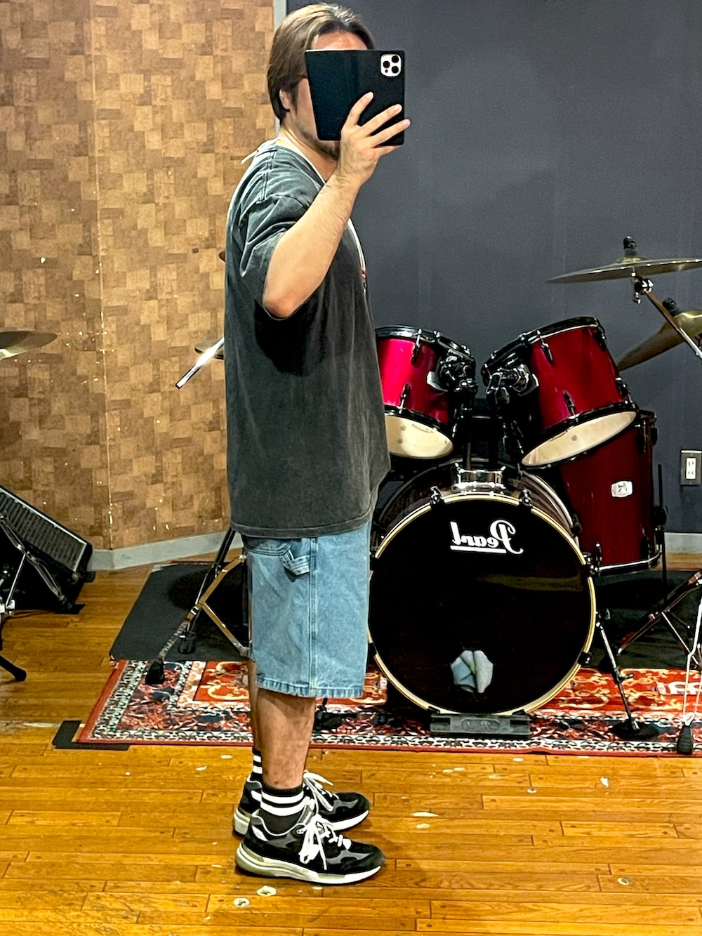 ブラック系のTシャツ/カットソー、ブルー系のデニムパンツ、ブラック系のスニーカーを着用したメンズの秋コーディネートの2枚目の写真