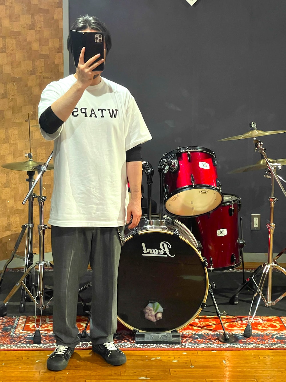 ホワイト系のTシャツ/カットソー、グレー系のスラックス、ブラック系のスニーカーを着用したメンズの夏コーディネートの2枚目の写真