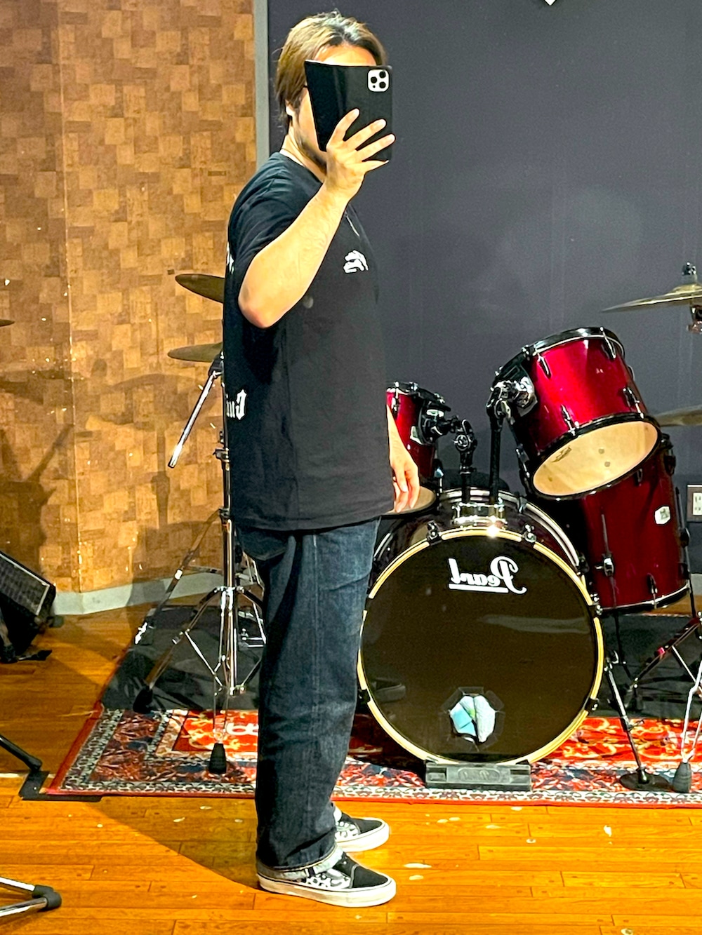 ブラック系のTシャツ/カットソー、ブルー系のデニムパンツ、ブラック系のスニーカーを着用したメンズの秋コーディネートの2枚目の写真