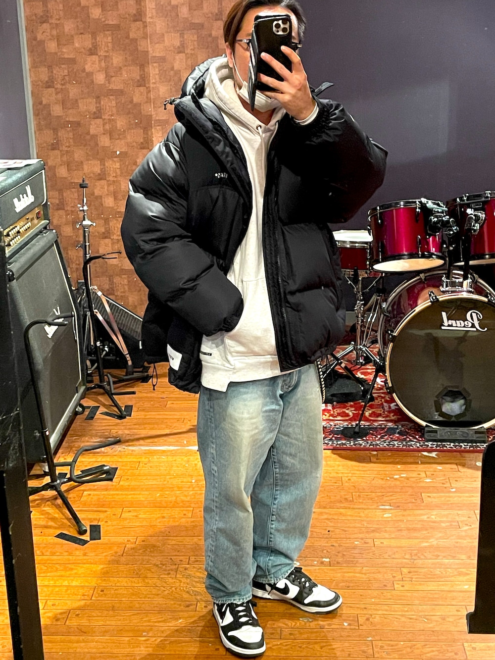 ブラック系のダウンジャケット/コート、グレー系のパーカー、ブルー系のデニムパンツを着用したメンズの冬コーディネートの3枚目の写真