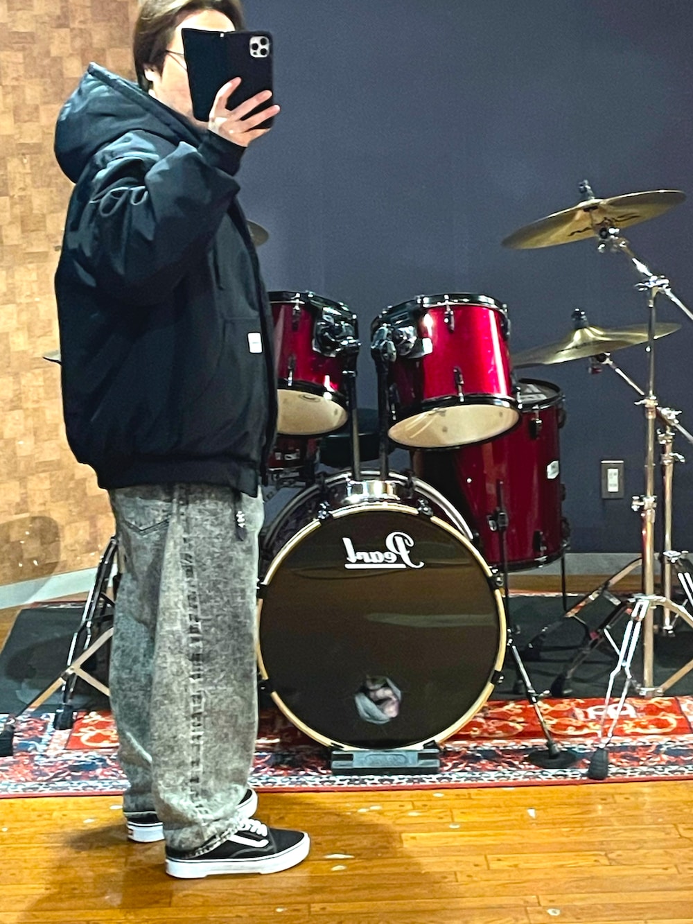 ブラック系のナイロンジャケット、ブラック系のパーカー、グレー系のデニムパンツを着用したメンズの春コーディネートの2枚目の写真