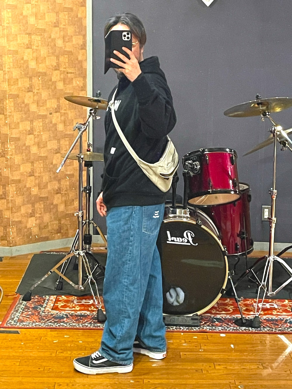 ブラック系のパーカー、ブルー系のデニムパンツ、ブラック系のスニーカーを着用したメンズの春コーディネートの3枚目の写真