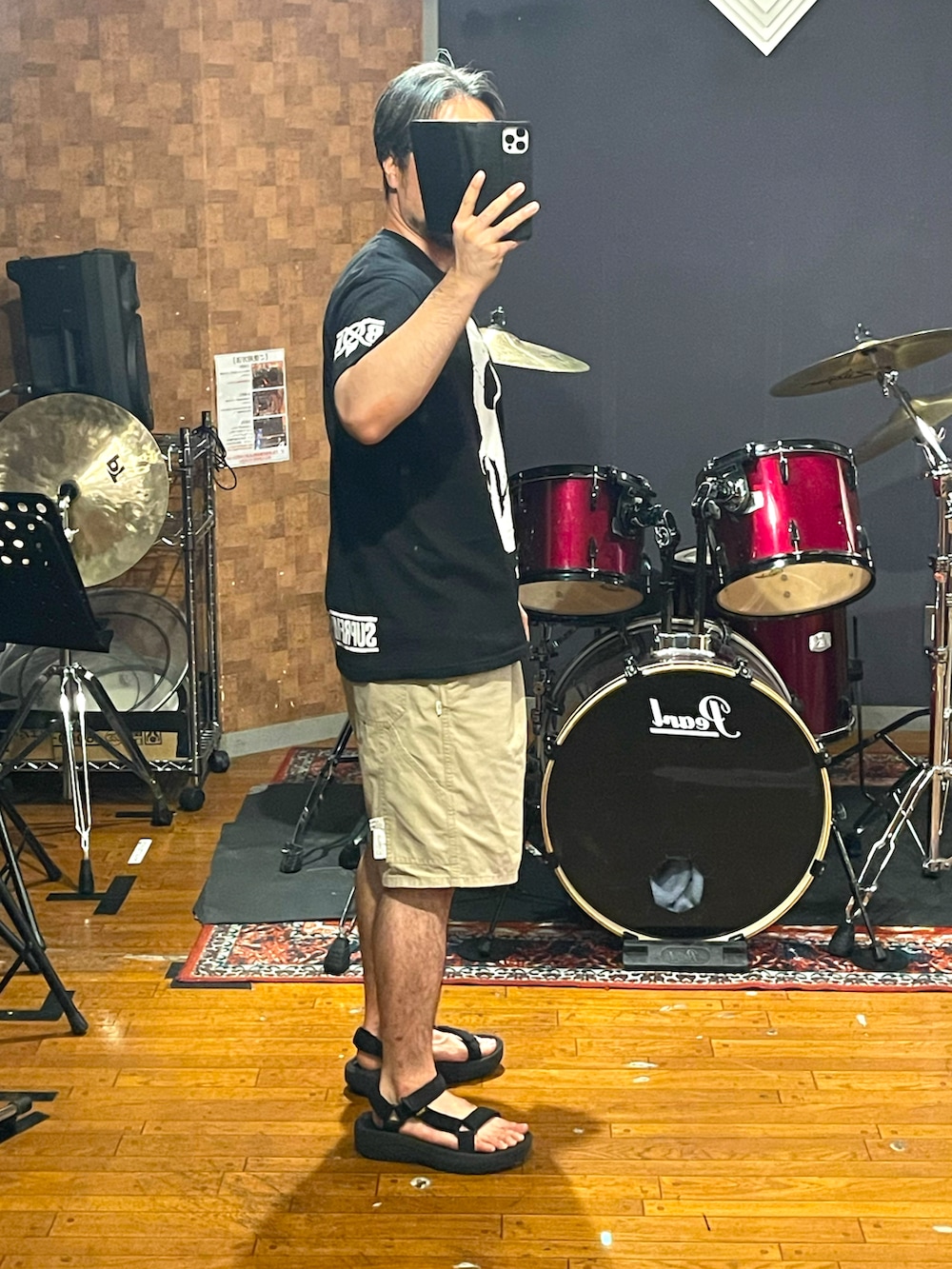 ブラック系のTシャツ/カットソー、ベージュ系のパンツ、ブラック系のサンダルを着用したメンズの夏コーディネートの3枚目の写真