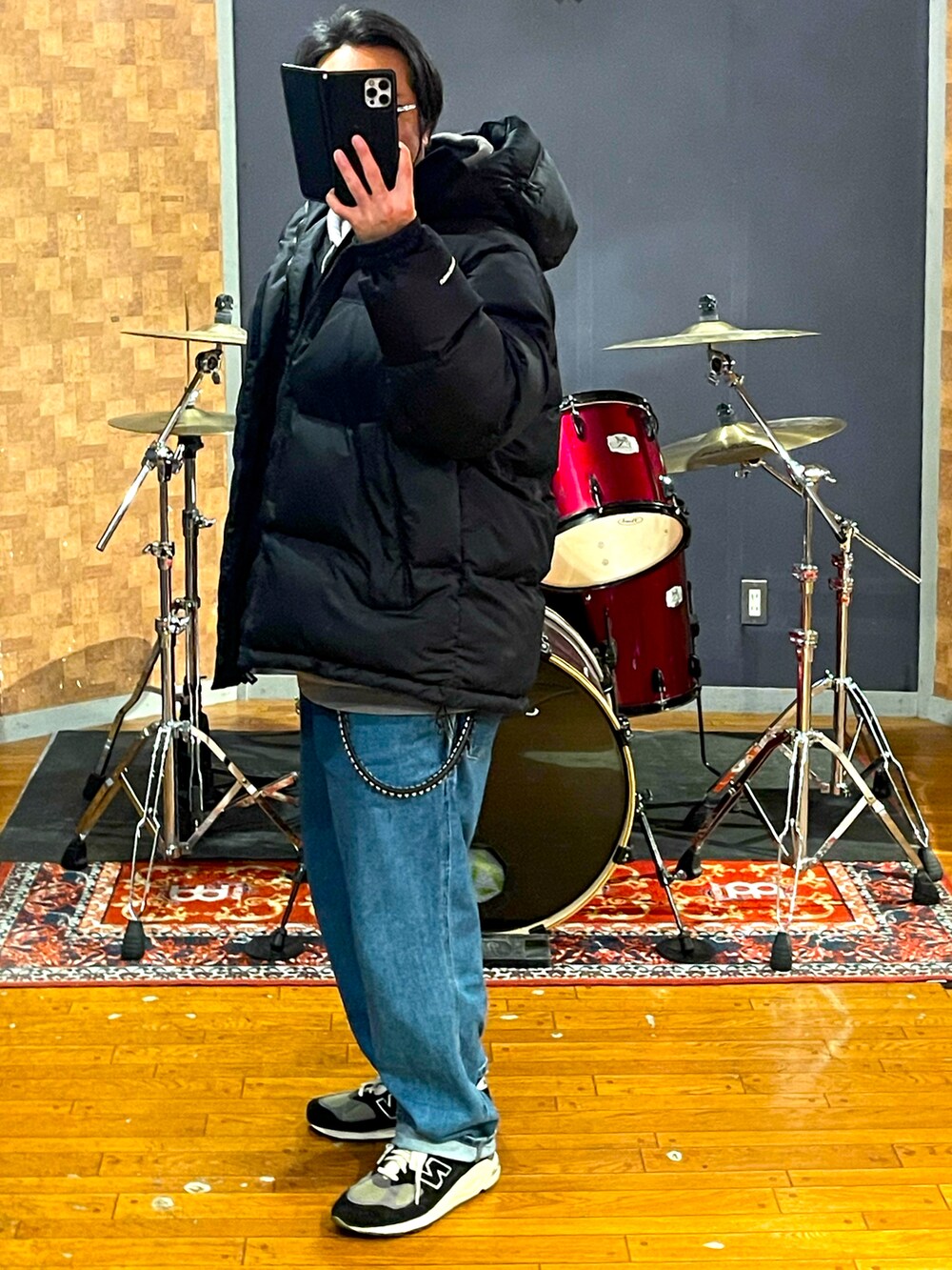 ブラック系のダウンジャケット/コート、ブルー系のデニムパンツ、ブルー系のスニーカーを着用したメンズの冬コーディネートの3枚目の写真