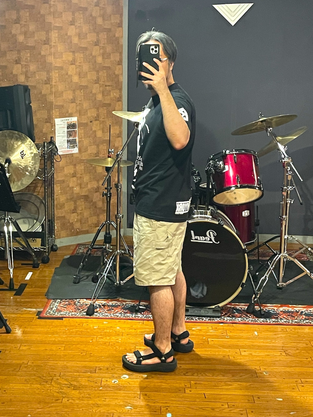 ブラック系のTシャツ/カットソー、ベージュ系のパンツ、ブラック系のサンダルを着用したメンズの夏コーディネートの2枚目の写真