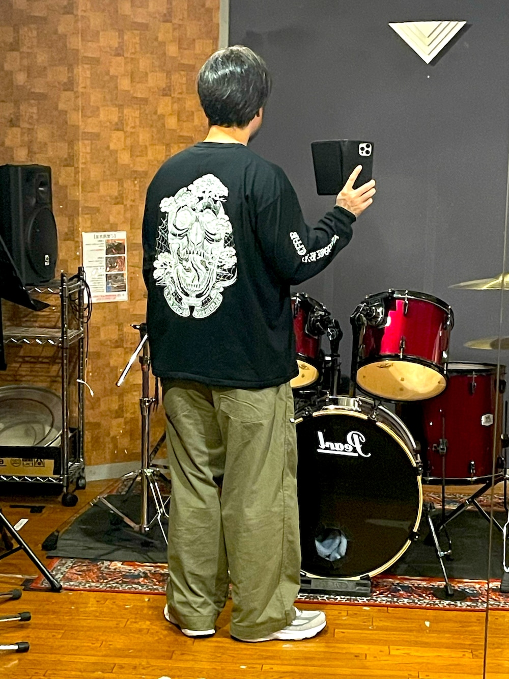 ブラック系のTシャツ/カットソー、グリーン系のパンツ、グレー系のスニーカーを着用したメンズの秋コーディネートの4枚目の写真