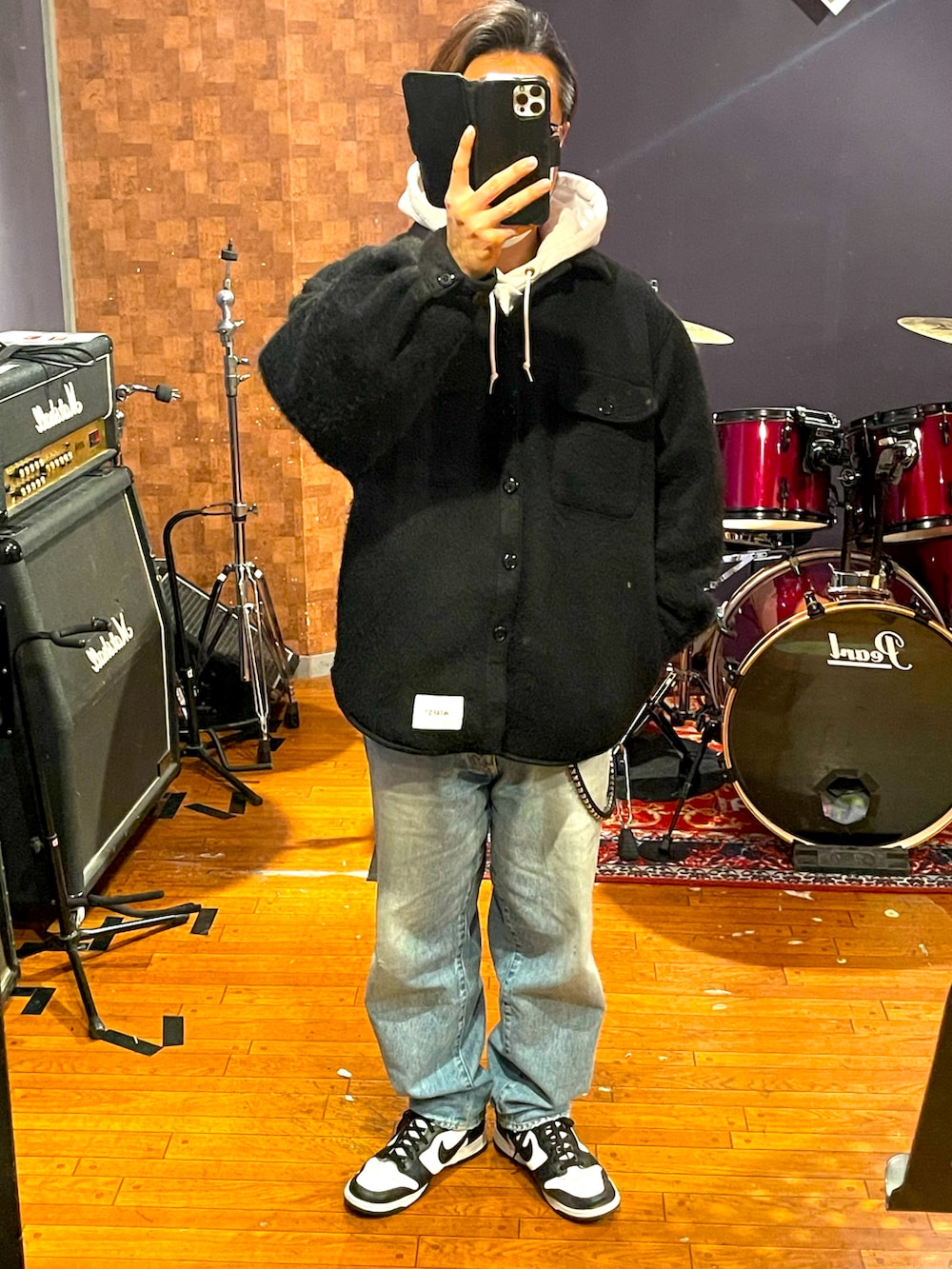 ブラック系のジャケット/アウター、ブルー系のデニムパンツ、ホワイト系のスニーカーを着用したメンズの春コーディネートの2枚目の写真