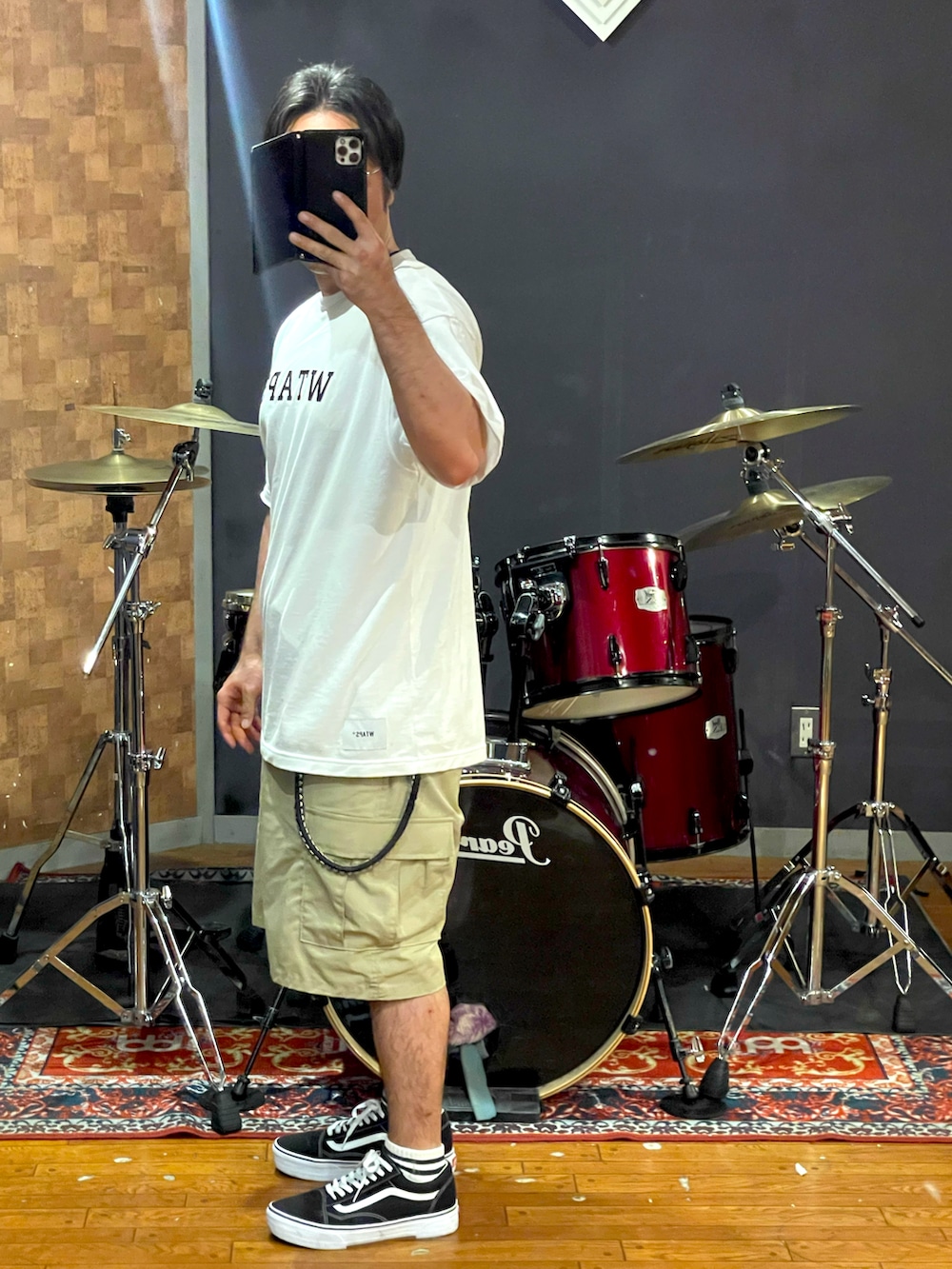ホワイト系のTシャツ/カットソー、ベージュ系のカーゴパンツ、ブラック系のスニーカーを着用したメンズの夏コーディネートの4枚目の写真
