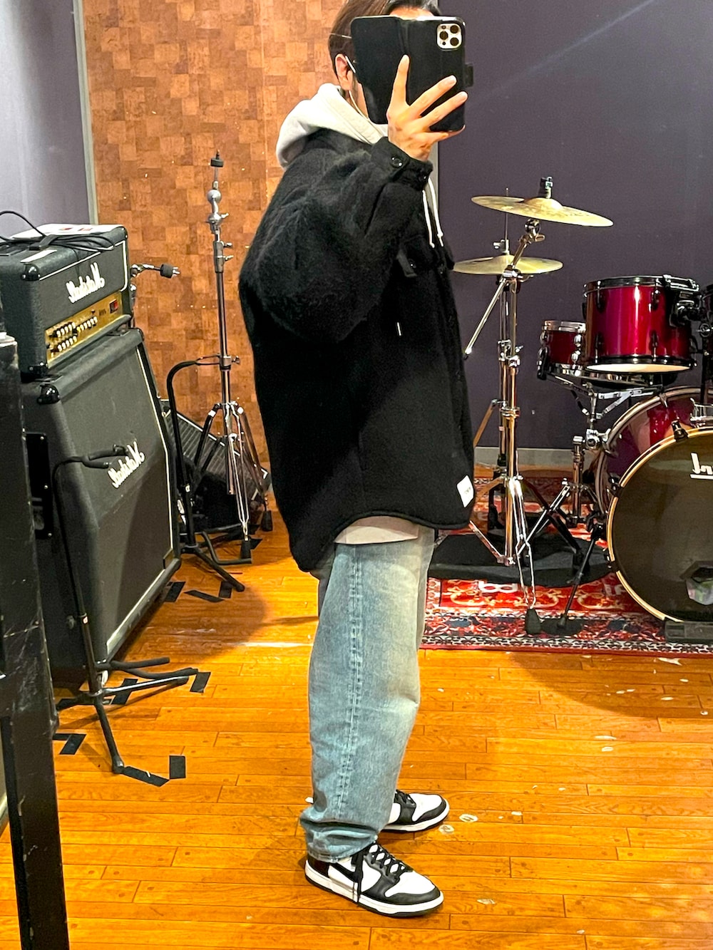 ブラック系のジャケット/アウター、ブルー系のデニムパンツ、ホワイト系のスニーカーを着用したメンズの春コーディネートの3枚目の写真