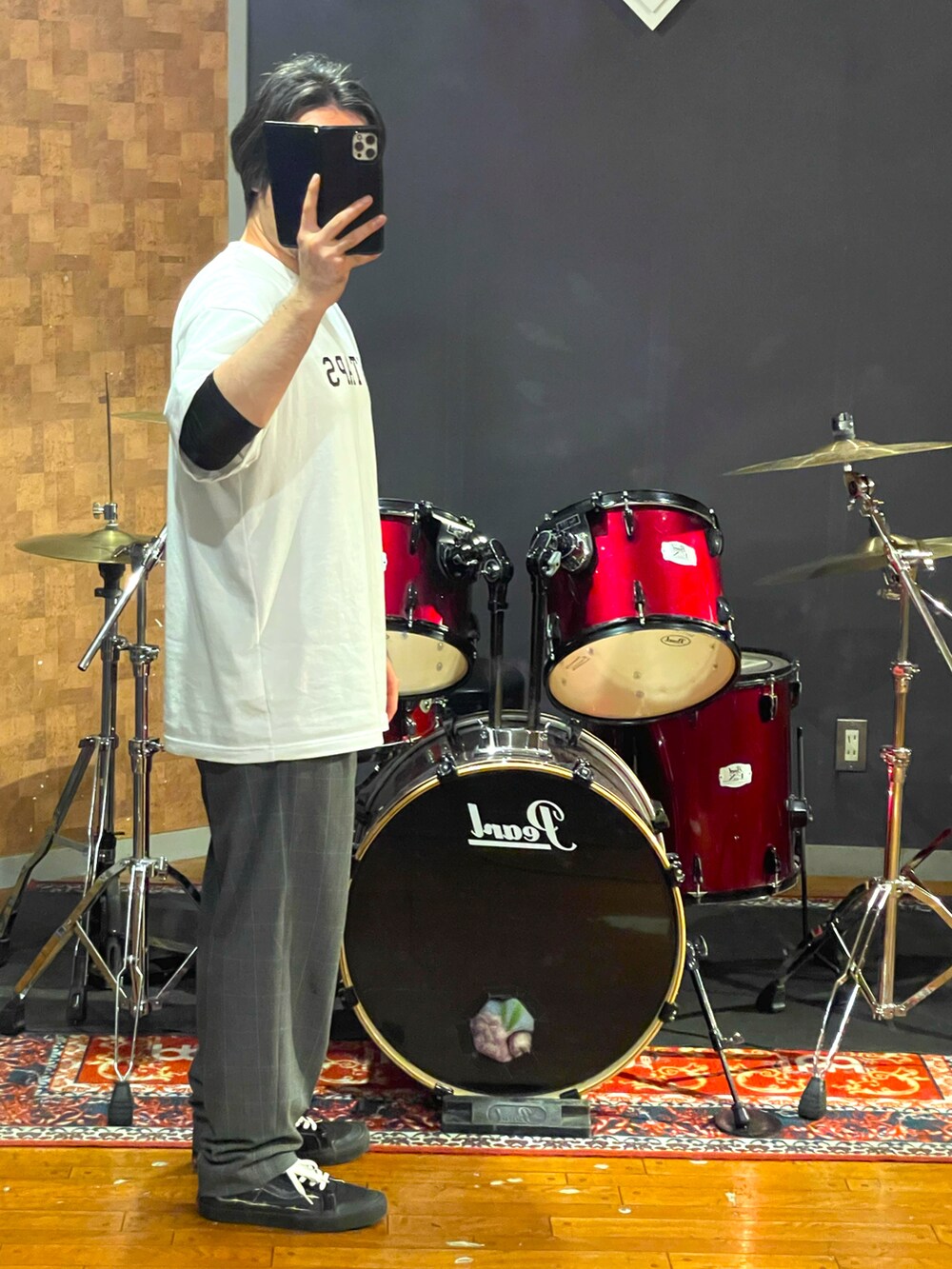 ホワイト系のTシャツ/カットソー、グレー系のスラックス、ブラック系のスニーカーを着用したメンズの夏コーディネートの3枚目の写真