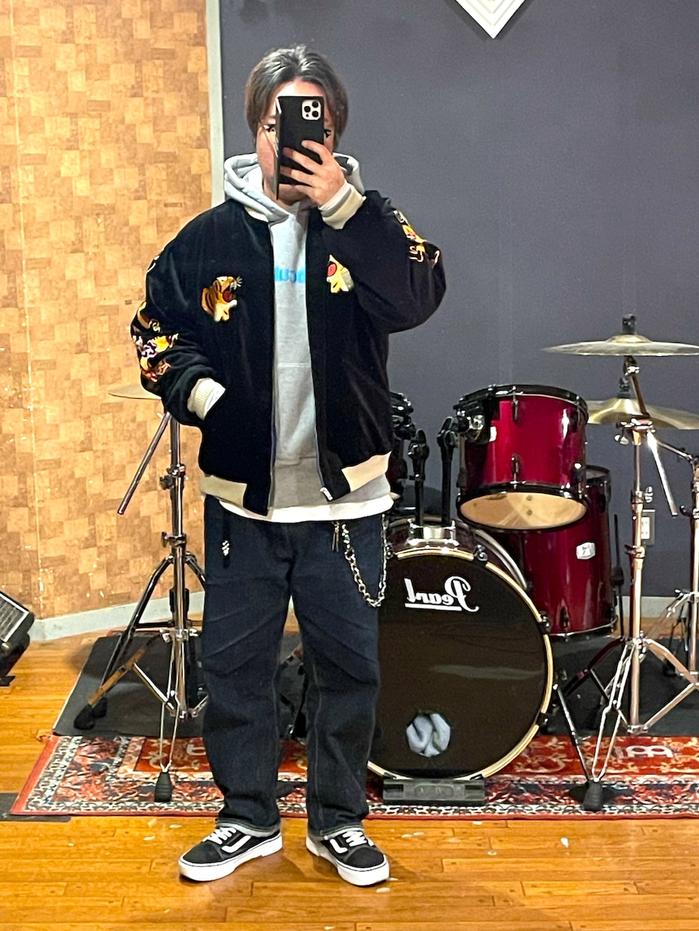 ブラック系のスカジャン、グレー系のパーカー、ブルー系のデニムパンツを着用したメンズの冬コーディネートの5枚目の写真