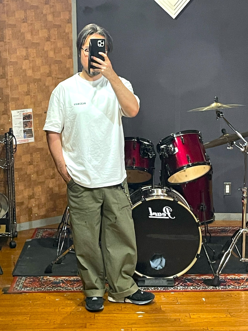 ホワイト系のTシャツ/カットソー、グリーン系のパンツ、ブラック系のスニーカーを着用したメンズの秋コーディネートの4枚目の写真