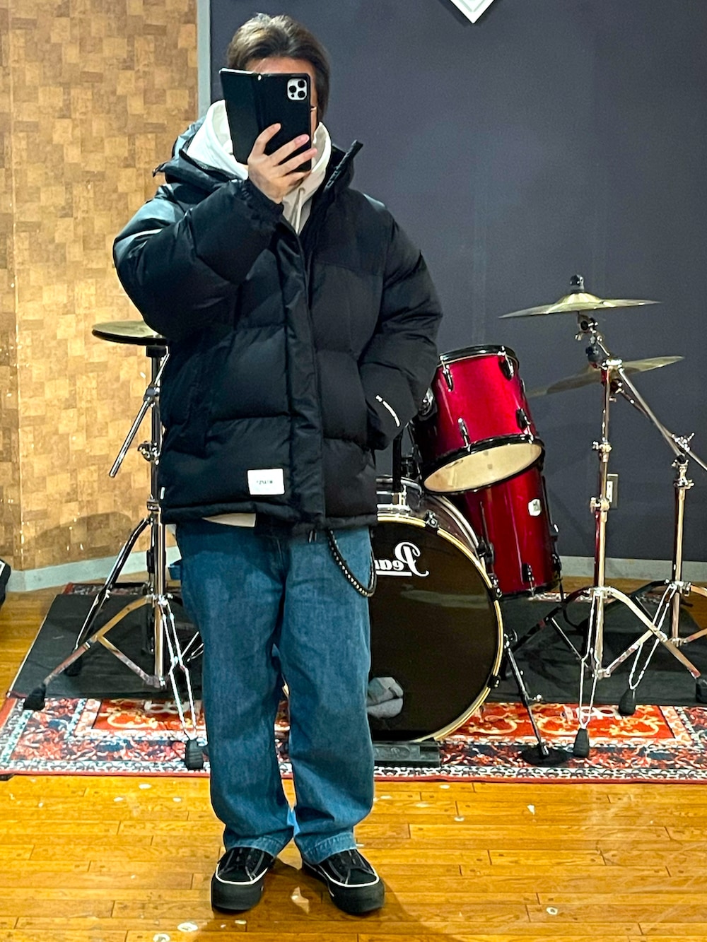 ブラック系のダウンジャケット/コート、ブルー系のデニムパンツ、ブラック系のスニーカーを着用したメンズの冬コーディネートの5枚目の写真