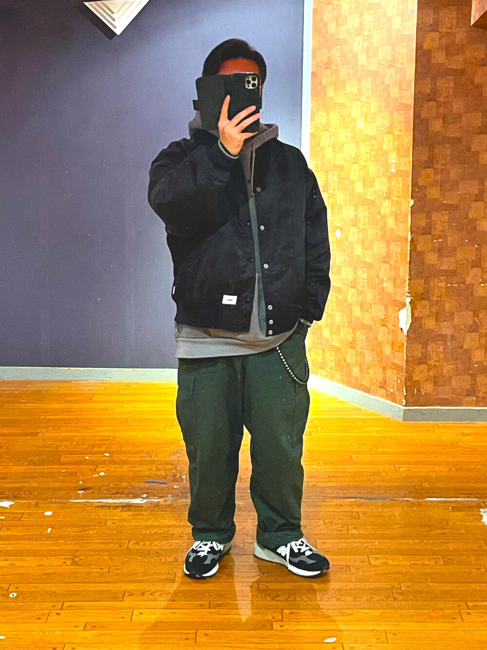 ブラック系のジャケット/アウター、グレー系のパーカー、グリーン系のカーゴパンツを着用したメンズの春コーディネートの3枚目の写真