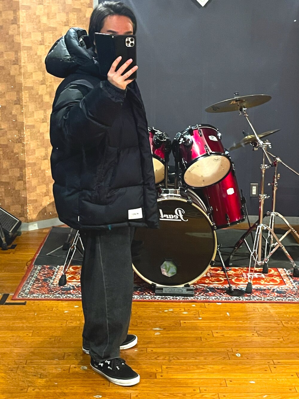 ブラック系のダウンジャケット/コート、ブラック系のパーカー、ブラック系のデニムパンツを着用したメンズの冬コーディネートの3枚目の写真