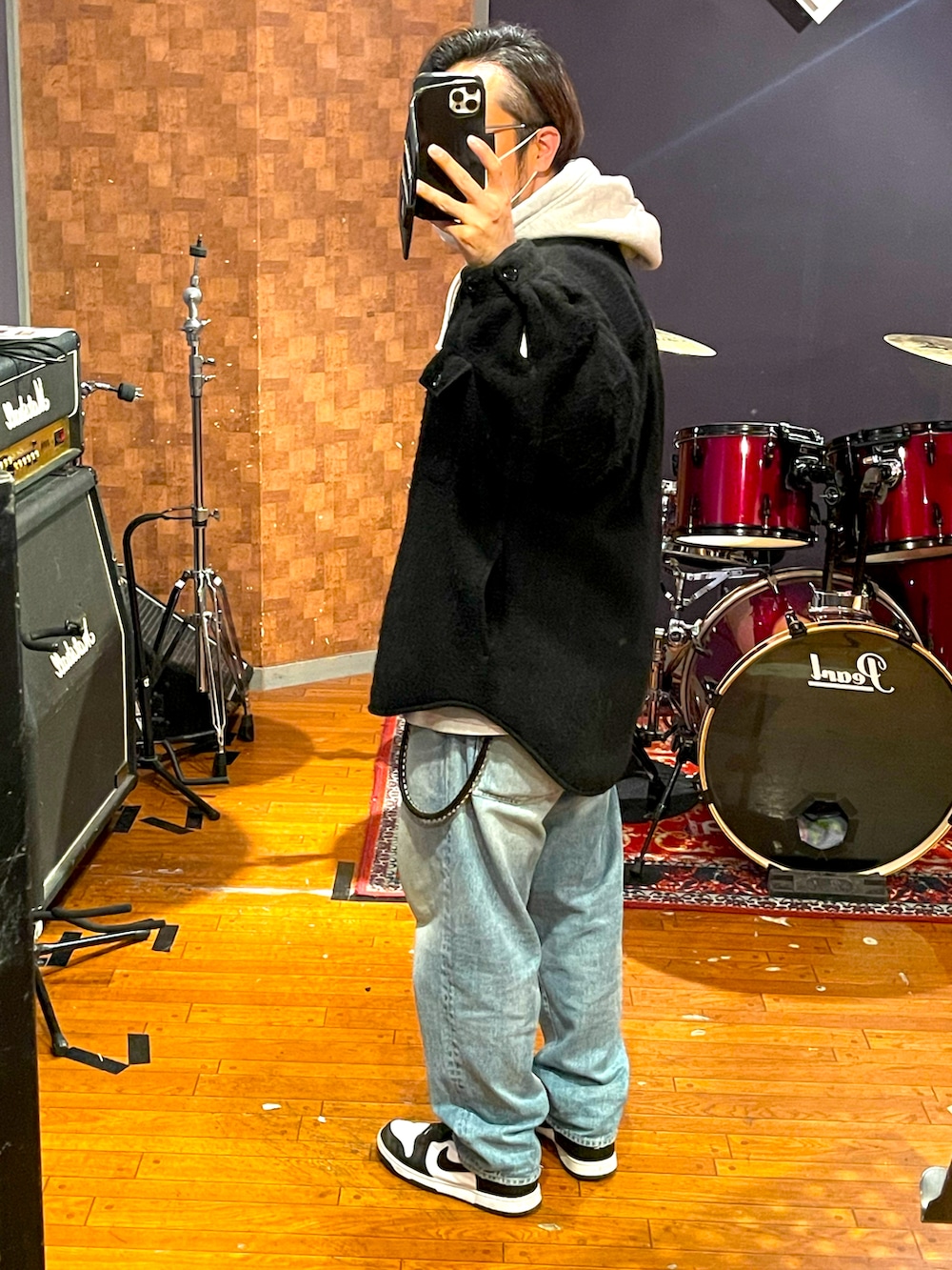 ブラック系のジャケット/アウター、ブルー系のデニムパンツ、ホワイト系のスニーカーを着用したメンズの春コーディネートの4枚目の写真