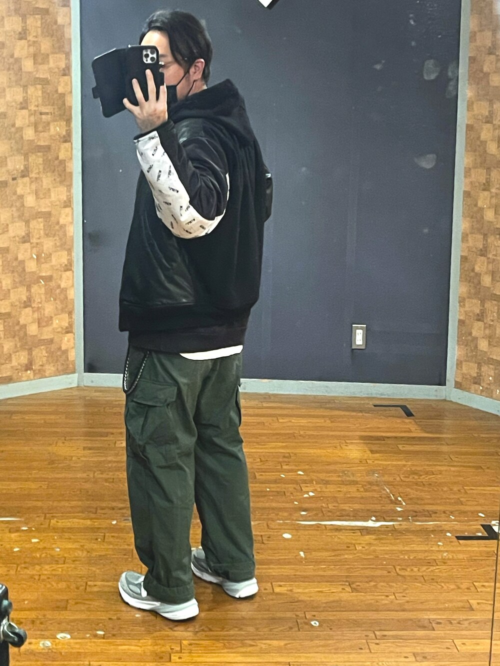 ブラック系のMA-1、ブラック系のパーカー、グリーン系のカーゴパンツを着用したメンズの秋コーディネートの2枚目の写真