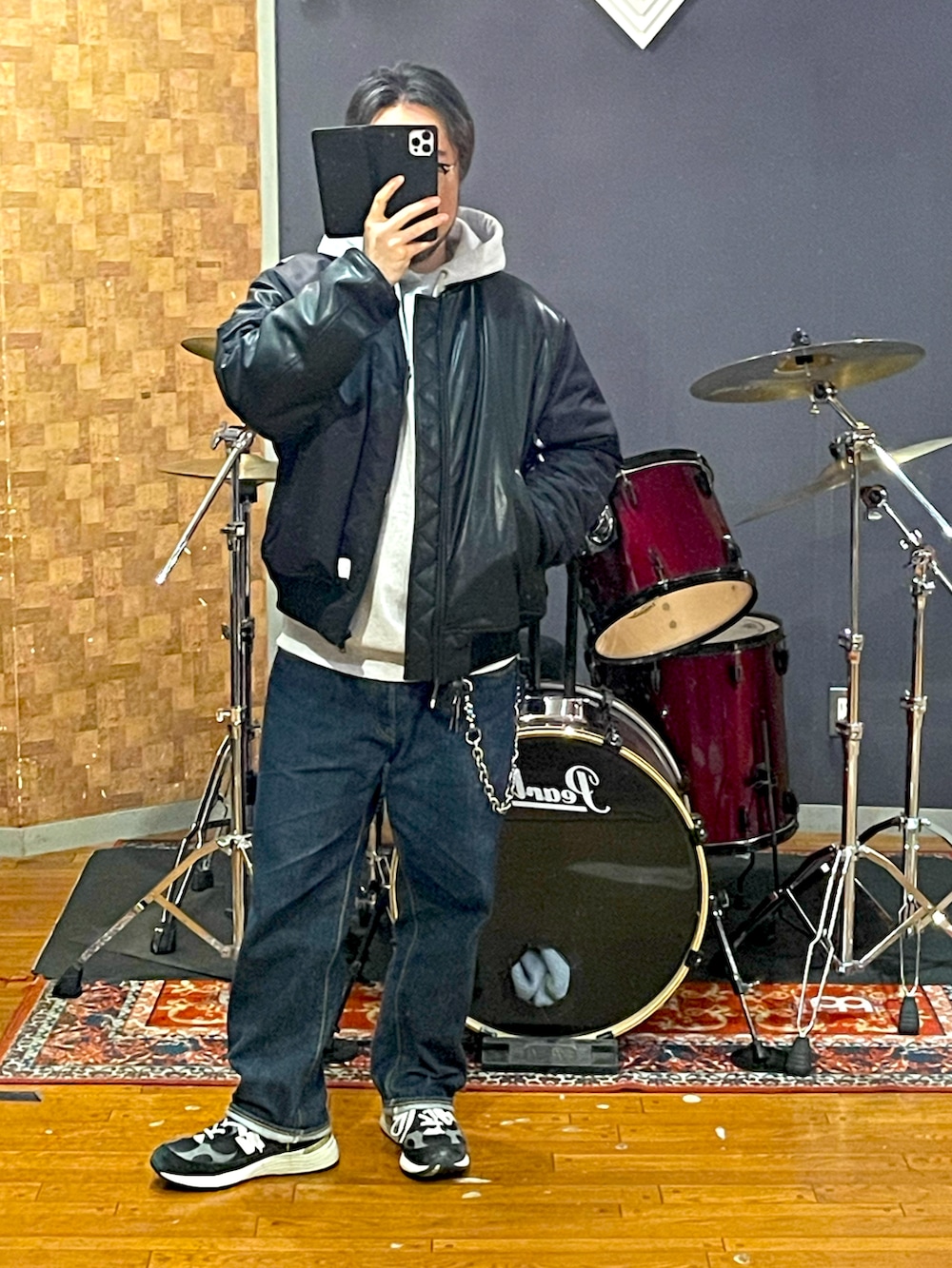 ブラック系のMA-1、グレー系のパーカー、ブルー系のデニムパンツを着用したメンズの春コーディネートの4枚目の写真