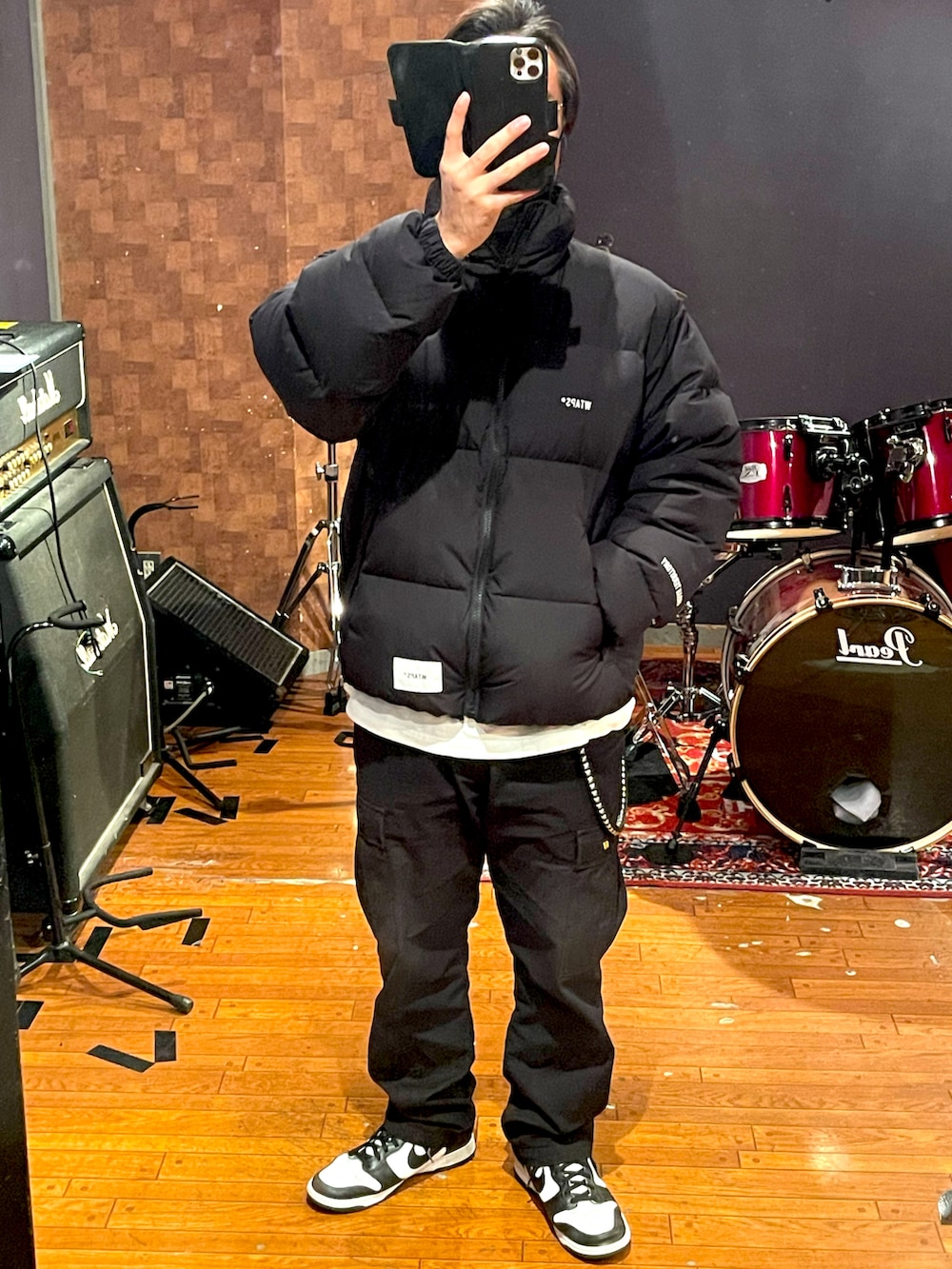 ブラック系のダウンジャケット/コート、ホワイト系のTシャツ/カットソー、ブラック系のカーゴパンツを着用したメンズの冬コーディネートの4枚目の写真