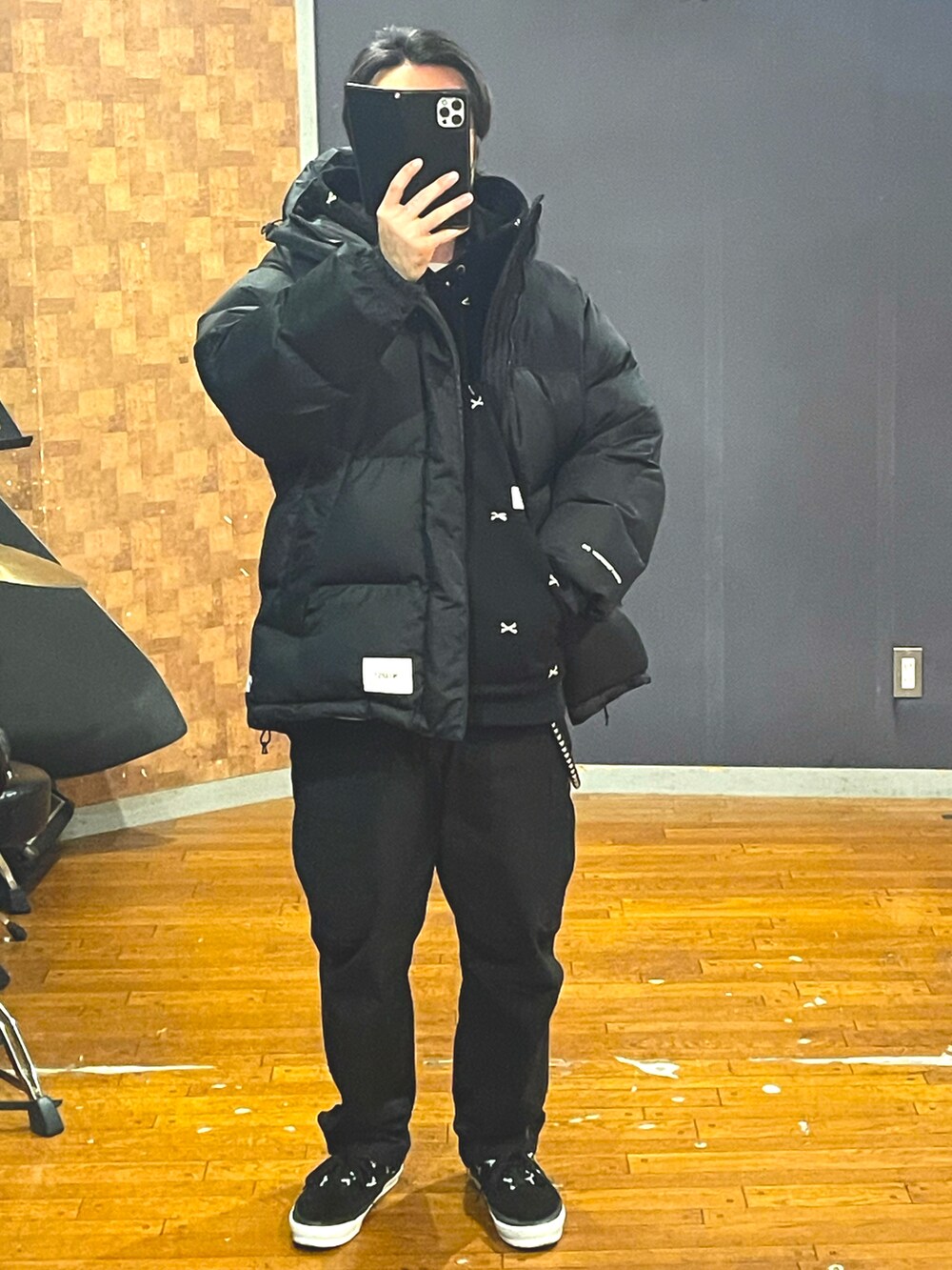 ブラック系のダウンジャケット/コート、ブラック系のパーカー、ブラック系のカーゴパンツを着用したメンズの冬コーディネートの4枚目の写真