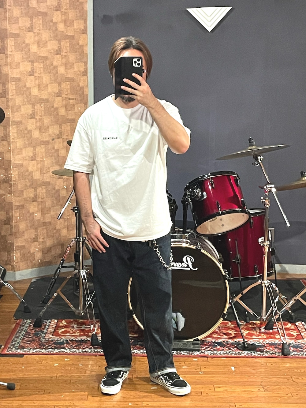 ホワイト系のTシャツ/カットソー、ブルー系のデニムパンツ、ブラック系のスニーカーを着用したメンズの秋コーディネートの4枚目の写真