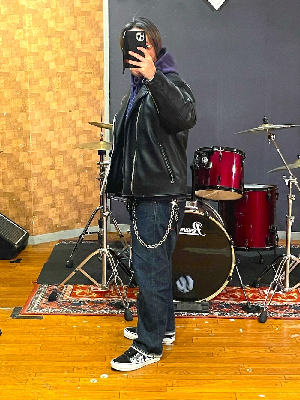 ブラック系のライダースジャケット、パープル系のパーカー、ブルー系のデニムパンツを着用したメンズの冬コーディネートの2枚目の写真