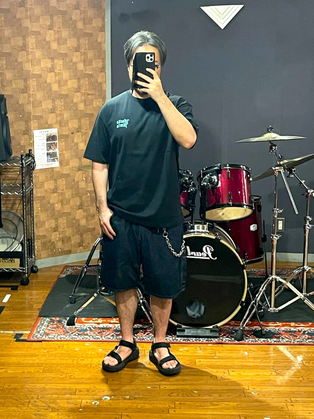 ブラック系のTシャツ/カットソー、ブルー系のデニムパンツ、ブラック系のサンダルを着用したメンズの夏コーディネートの4枚目の写真