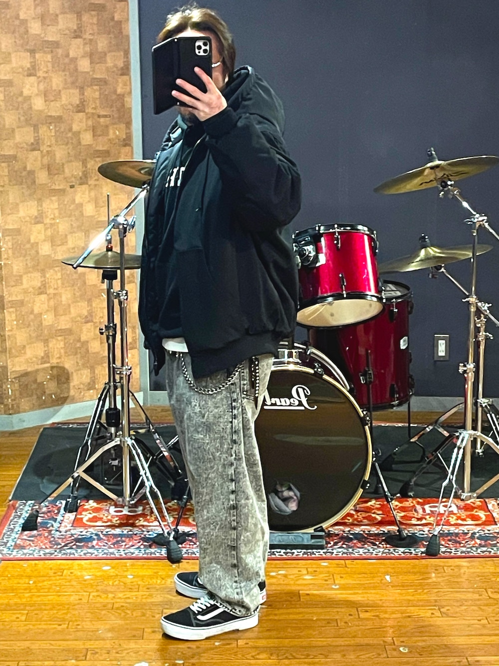 ブラック系のナイロンジャケット、ブラック系のパーカー、グレー系のデニムパンツを着用したメンズの春コーディネートの3枚目の写真