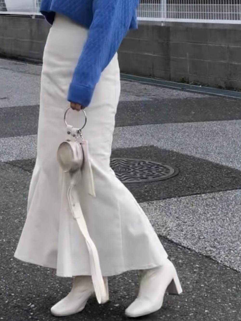 ブルー系のカーディガン/ボレロ、ホワイト系のスカート、ホワイト系のショルダーバッグを着用したレディースの冬コーディネートの2枚目の写真