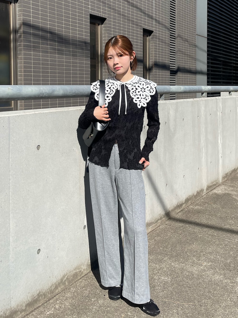 ブラック系のスニーカー、ブラック系のショルダーバッグ、グレー系のその他パンツを着用したレディースの冬コーディネートの3枚目の写真