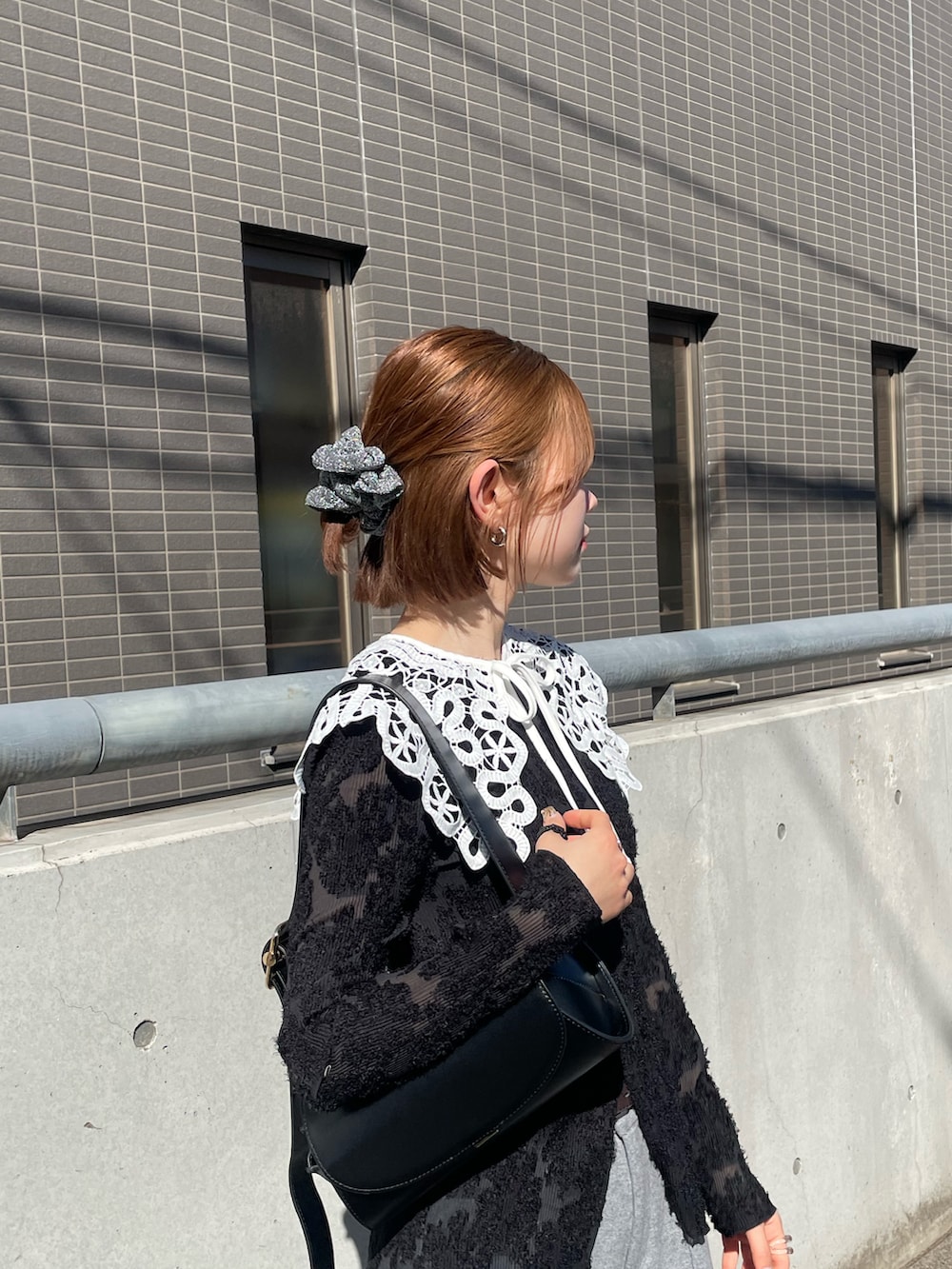 ブラック系のスニーカー、ブラック系のショルダーバッグ、グレー系のその他パンツを着用したレディースの冬コーディネートの4枚目の写真