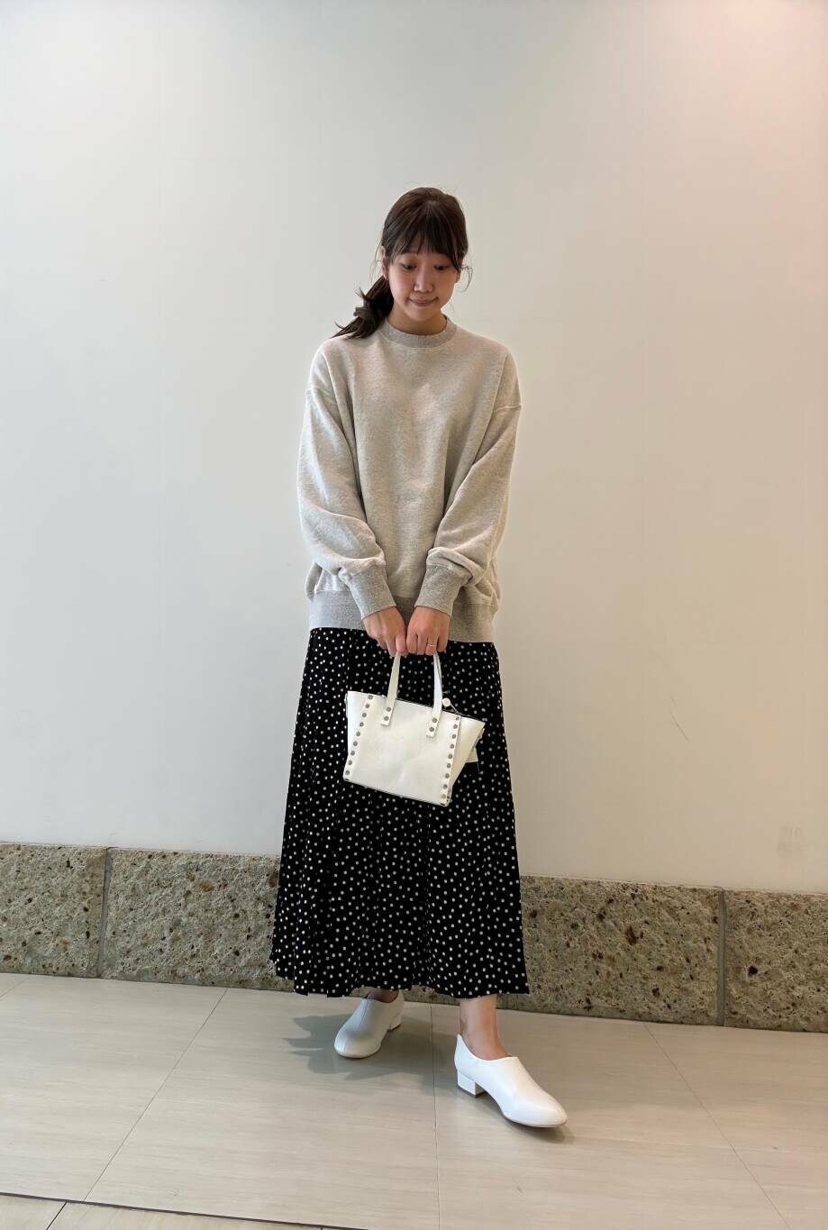 ホワイト系のショルダーバッグ、ホワイト系のその他シューズ、グレー系のスウェットを着用したレディースの秋コーディネートの2枚目の写真