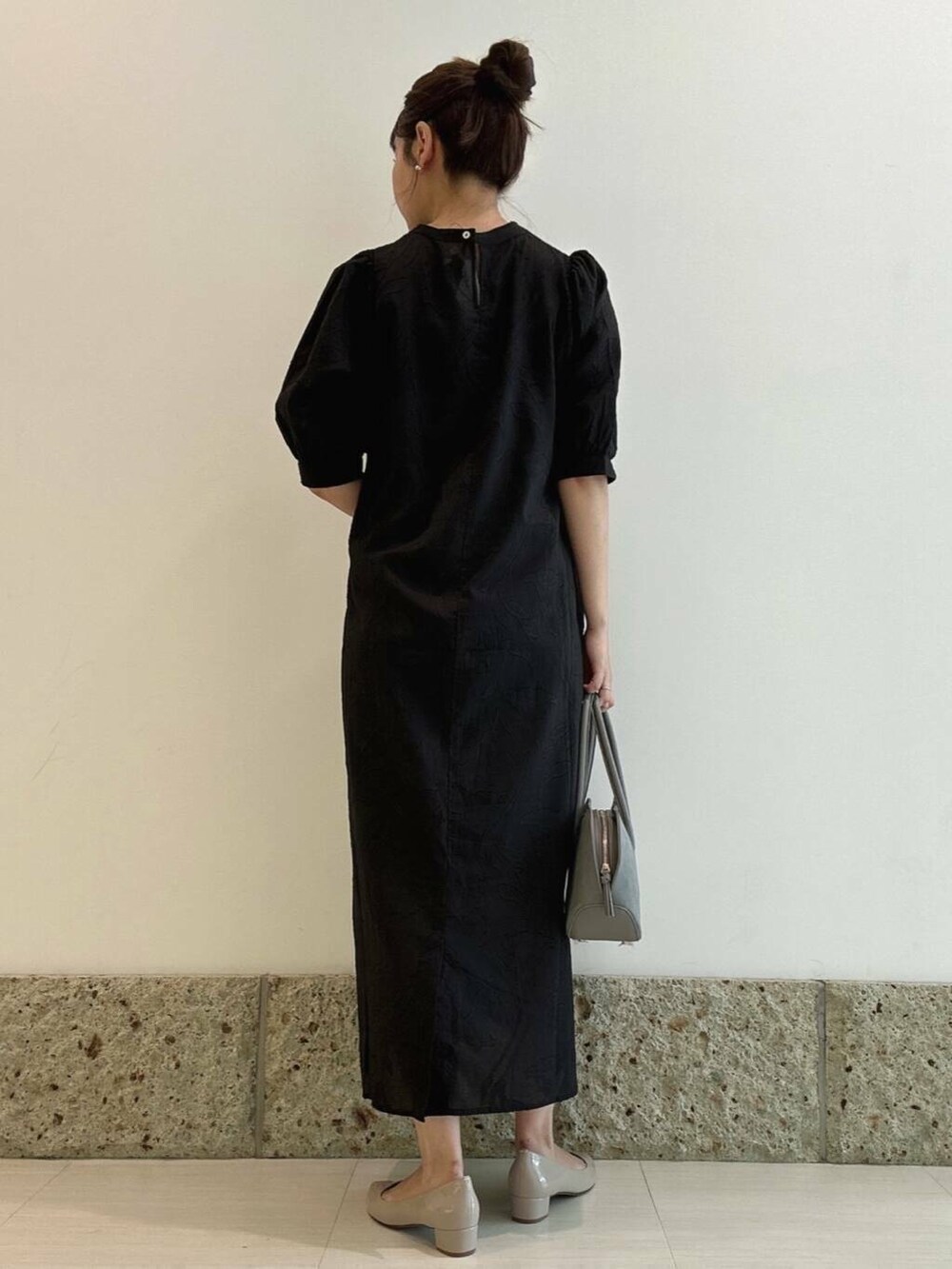 ベージュ系のパンプス、ブルー系のハンドバッグ、ブラック系のワンピースを着用したレディースの秋コーディネートの3枚目の写真