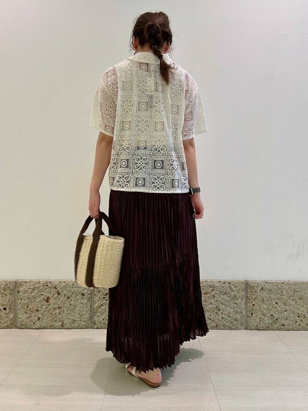 ホワイト系のハンドバッグ、ホワイト系のタンクトップ、ブラウン系のスカートを着用したレディースの夏コーディネートの4枚目の写真