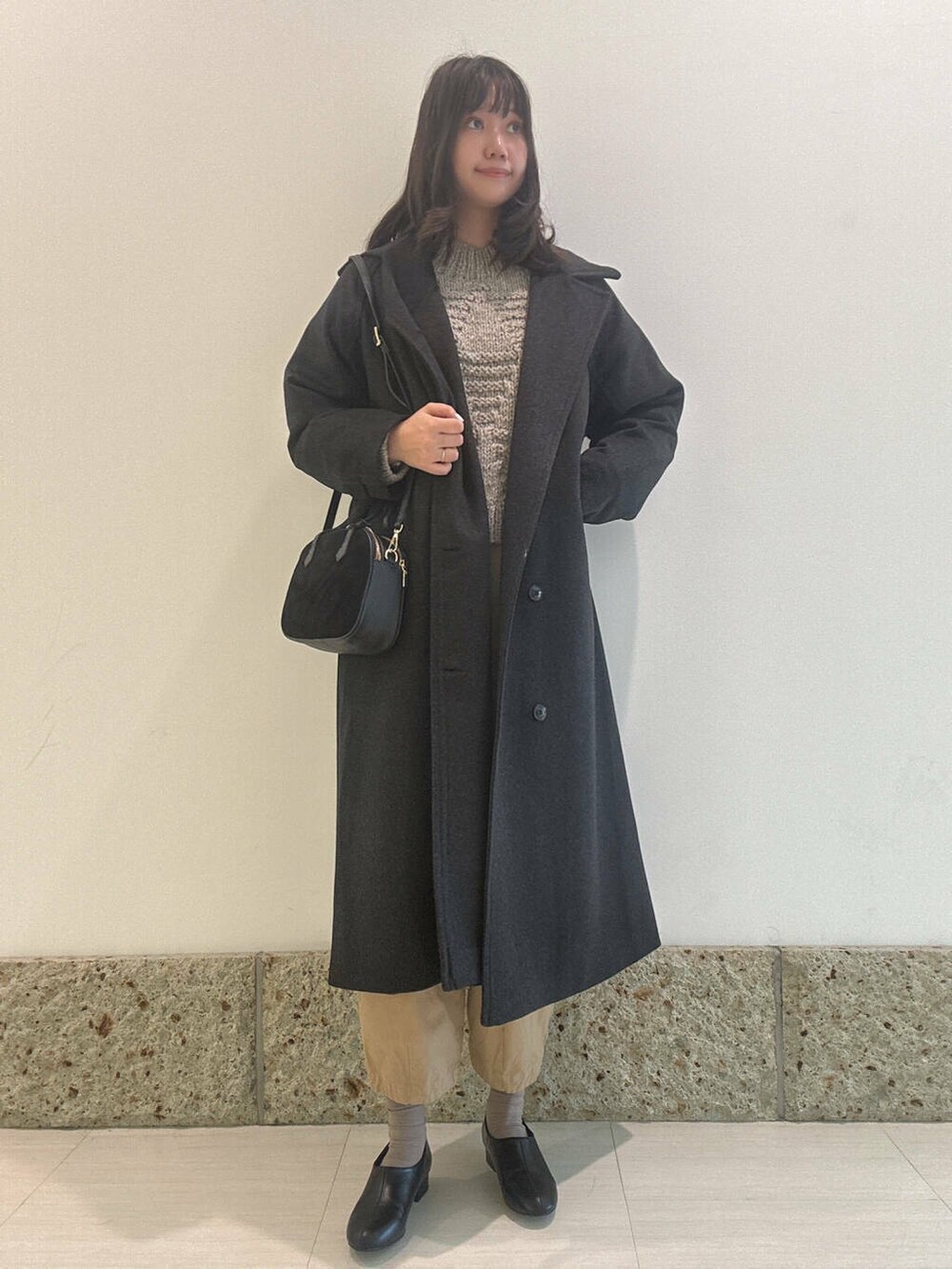 グレー系のニット/セーター、ブラック系のショルダーバッグ、ブラック系のその他シューズを着用したレディースの秋コーディネートの3枚目の写真