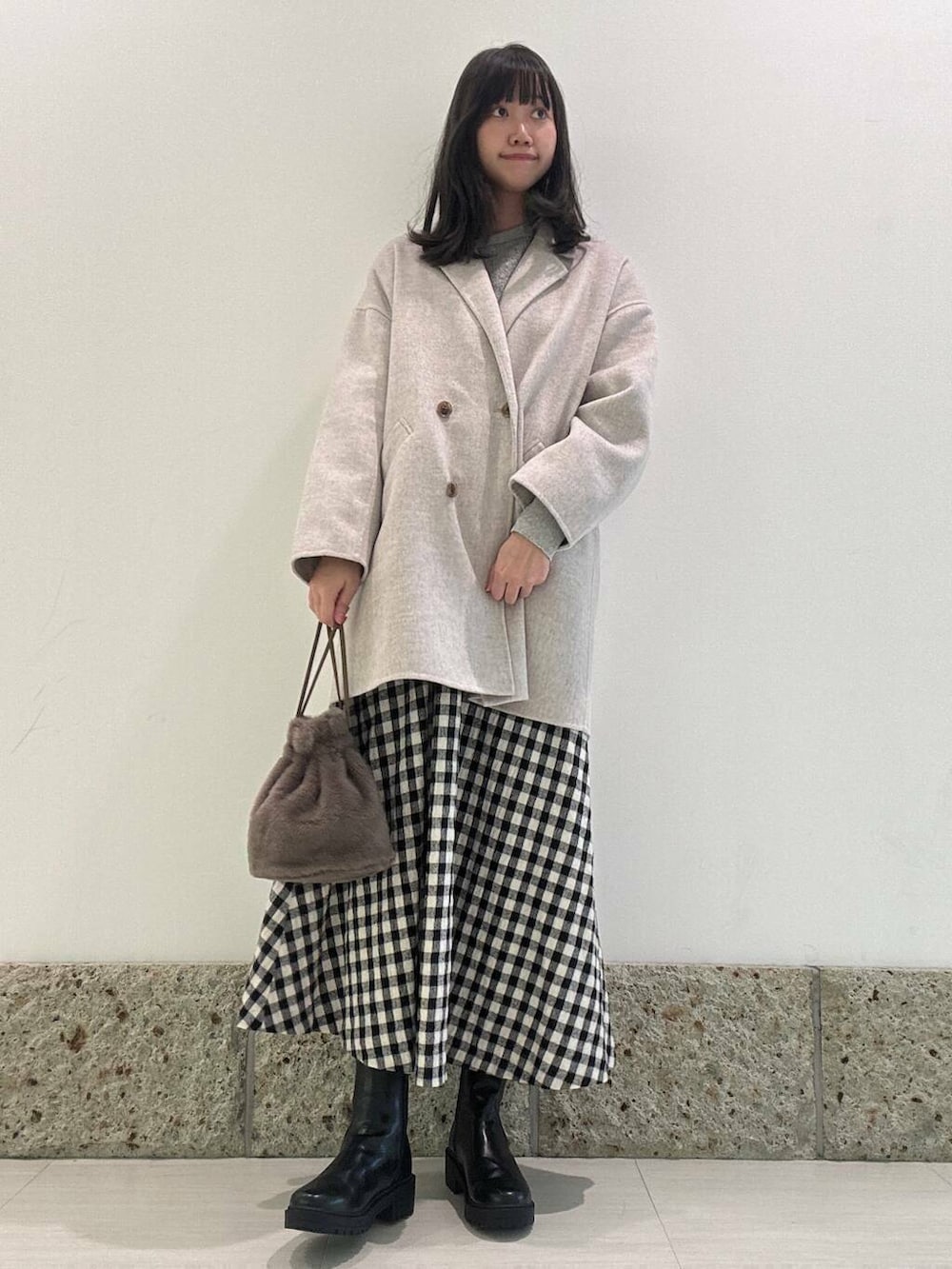 ベージュ系のその他アウター、ブラック系のブーツ、ブラウン系のショルダーバッグを着用したレディースの秋コーディネートの2枚目の写真