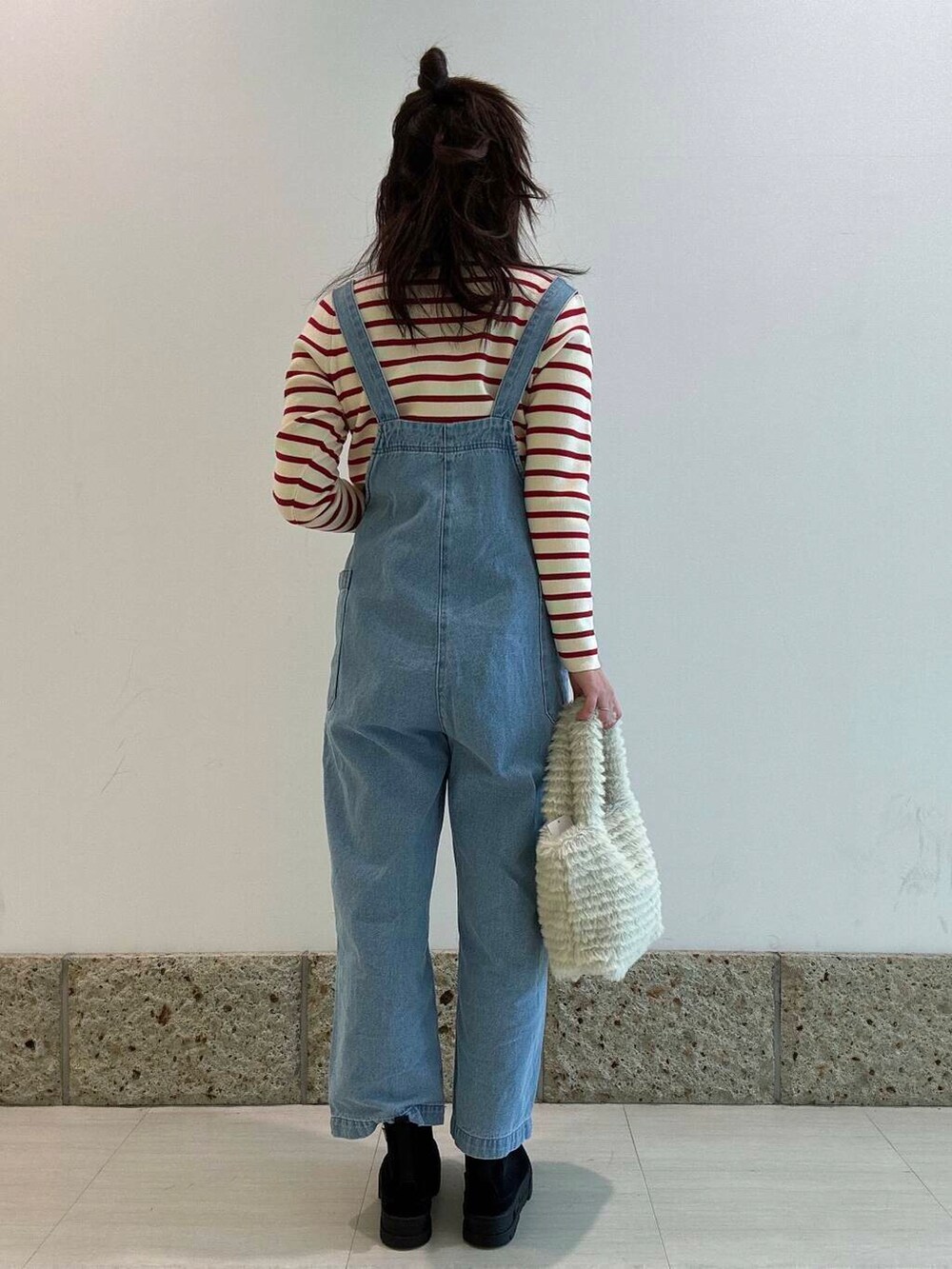 ブラック系のブーツ、グリーン系のトートバッグ、ブルー系のサロペット/オーバーオールを着用したレディースの冬コーディネートの3枚目の写真