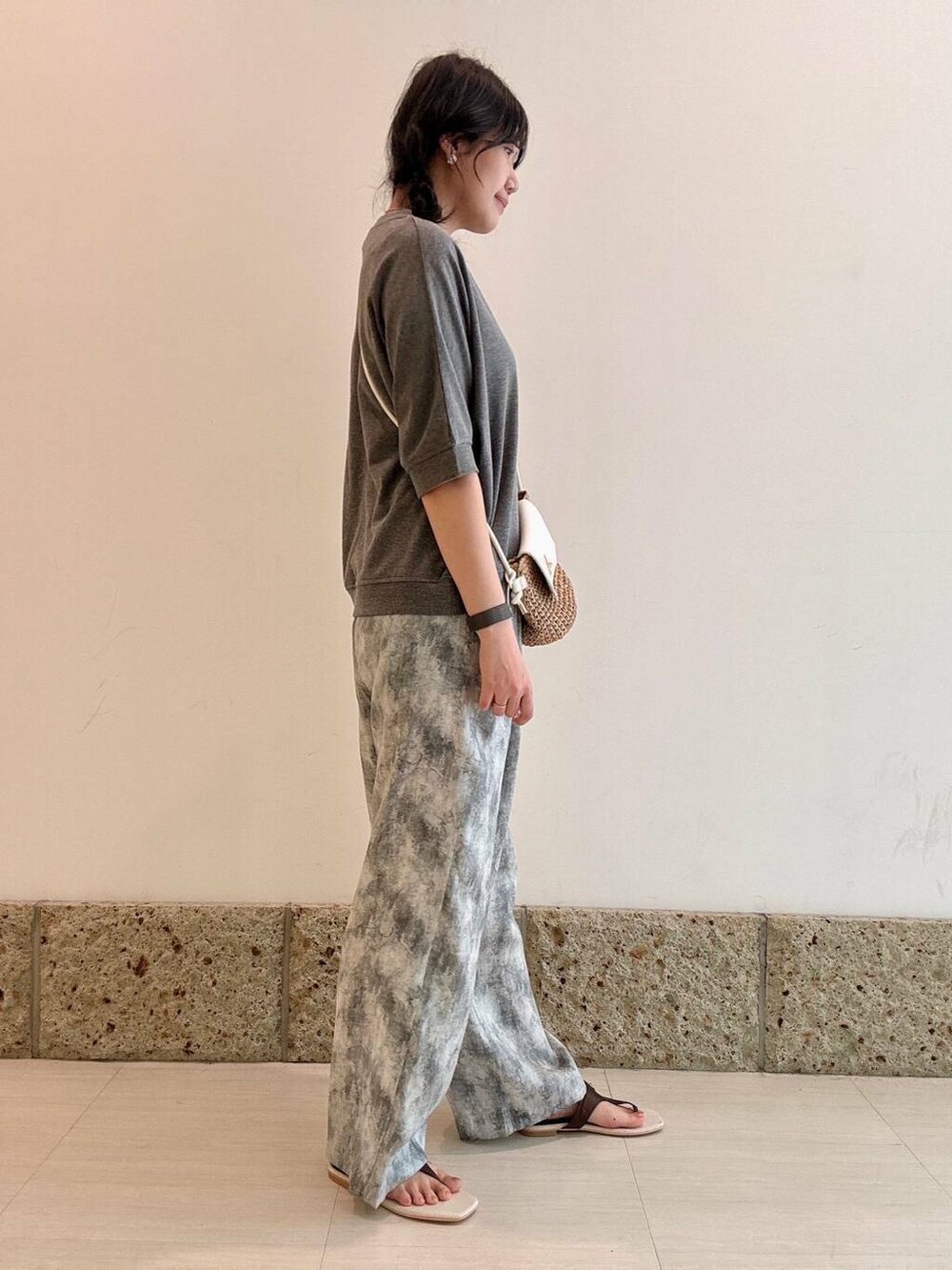 イエロー系のショルダーバッグ、ブラウン系のサンダル、グレー系のTシャツ/カットソーを着用したレディースの夏コーディネートの3枚目の写真