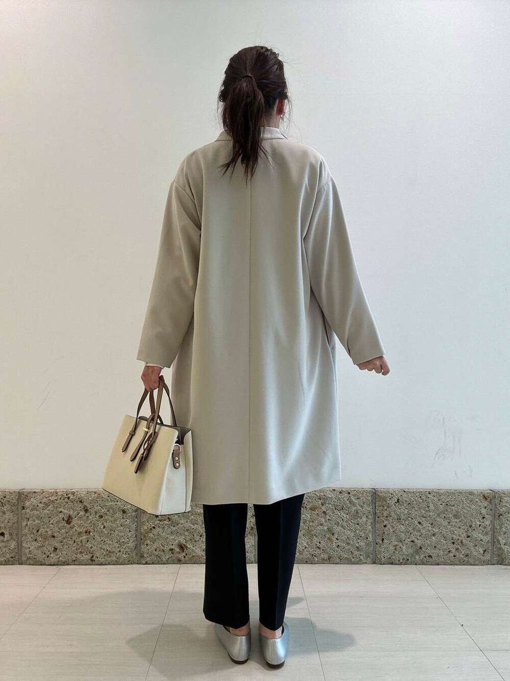 ホワイト系のトートバッグ、ブラック系のその他パンツ、ブラック系のベストを着用したレディースの冬コーディネートの6枚目の写真